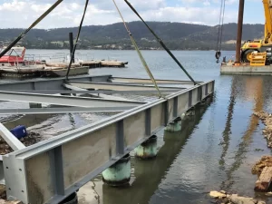 Expansive view of the 1000-foot slipway project, showcasing the long concrete ramp extending into the water, flanked by construction machinery