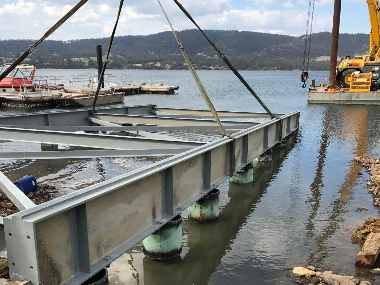 Expansive view of the 1000-foot slipway project, showcasing the long concrete ramp extending into the water, flanked by construction machinery
